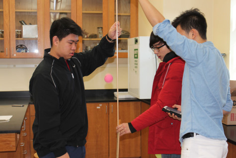 Students measure the height of a bouncing ball as part of a physics experiment. 