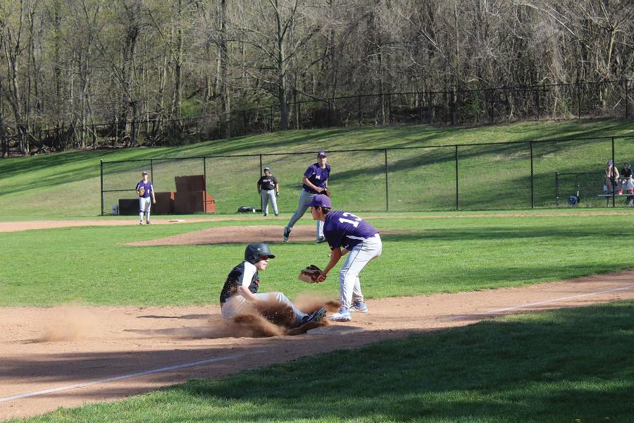 A Trevor Day player kicks up some dirt as he slides safely into 3rd base during a game at Clarke Field.  The Panthers, however, prevailed by a score of 7-4 in their first game of the season after many delays, mostly due to rainouts.