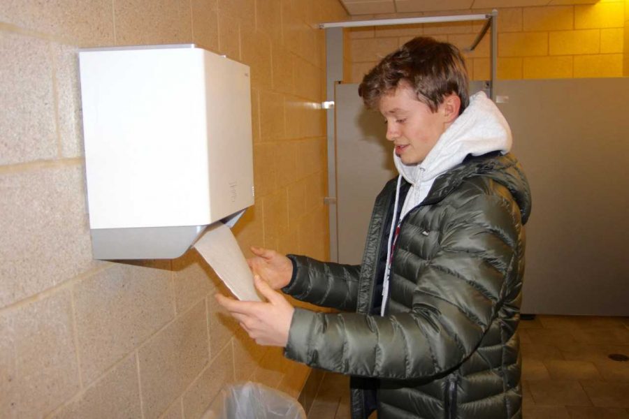 Sophomore Aidan Lothian grabs a paper towel from the automatic dispenser in the bathroom on the third floor of the FC. While the dispensers have a variety of benefits, they still produce a significant amount of waste. 