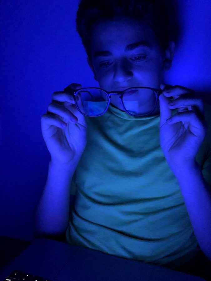 Brian Wolfson examines a pair of blue light glasses. These glasses are becoming more popular as schools and businesses shift to online platforms; they help protect the eyes from blue light, which can cause eye discomfort when exposed for long periods of time. 