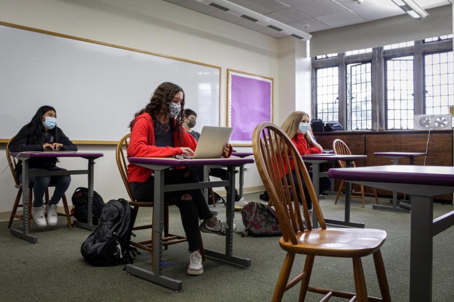 Students sit in rows as they participate in a hybrid class.  The desks which now occupy classrooms were a replacement for Harkness tables, which helped to facilitate the school's emphasis on discussion-based learning.