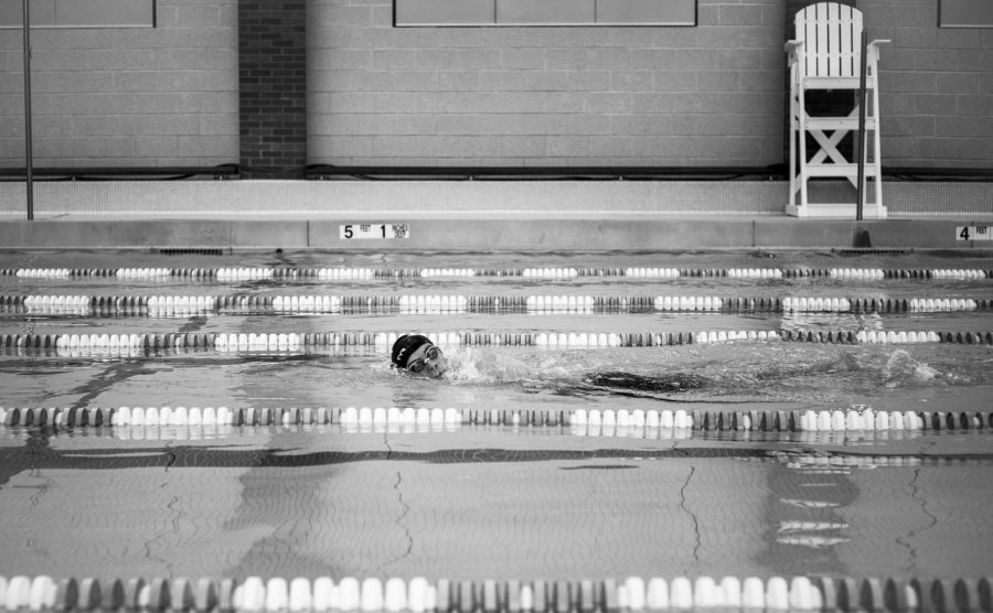 A Masters Student swims alone in one lane during an after school practice. This Winter, swim teams all over the country are changing the structure and focus of training, in order to keep athletes safe without masks. 