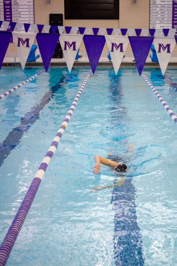 A Masters student swims alone in one lane during an afternoon practice. 