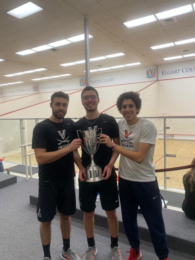 Taha Dinana 20 alongside teammates Omar El Torkey and Ali Hussein with the Mid-Atlantic Squash Conference Championship trophy.