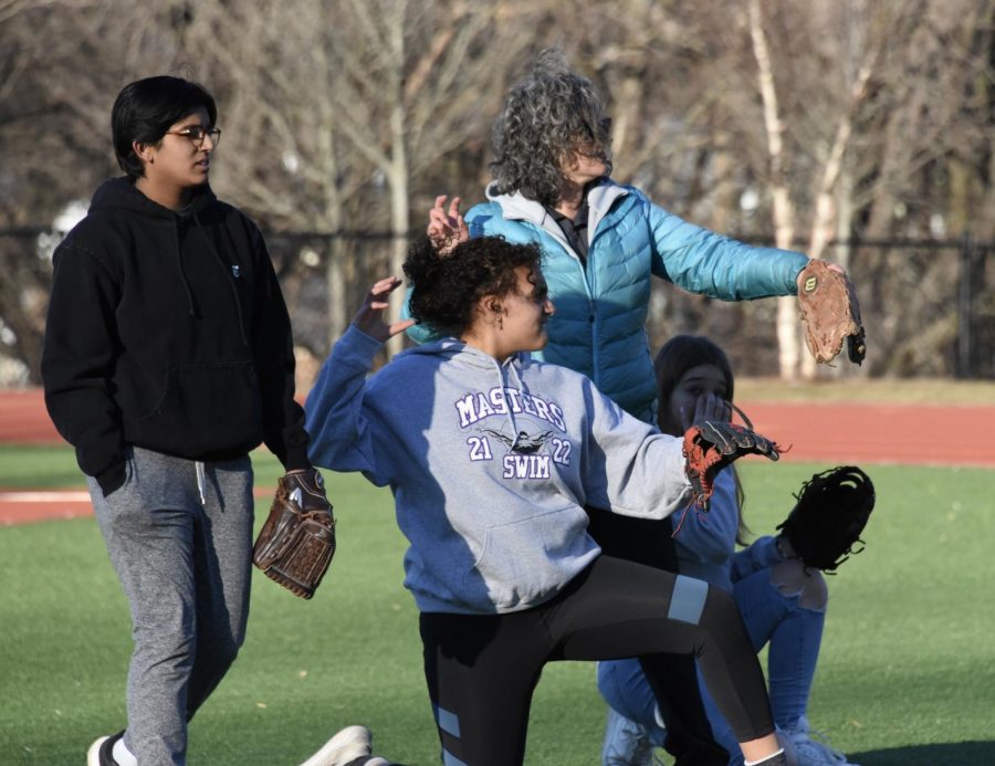 Coach Mikelle Sacco works with team members on proper throwing mechanics during a practice at the Greene Field. So far, the team has practiced there as well as on Evans Field. From left to right: Kira Ratan 22, Briana Diaz 22, Sibora Sadrijaj 24