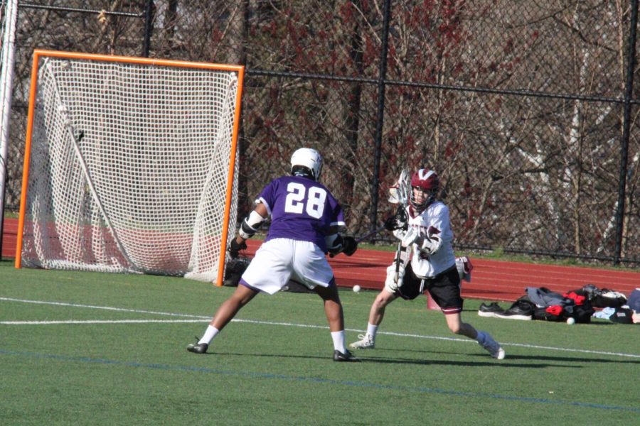 Ethan Yankey ’22 stops a Wooster midfielder in his tracks during the boys’ varsity lacrosse home game on April 8. Despite it being Yankey’s first year playing lacrosse, he has made his statement as one of the teams strongest and most physical defenders.
