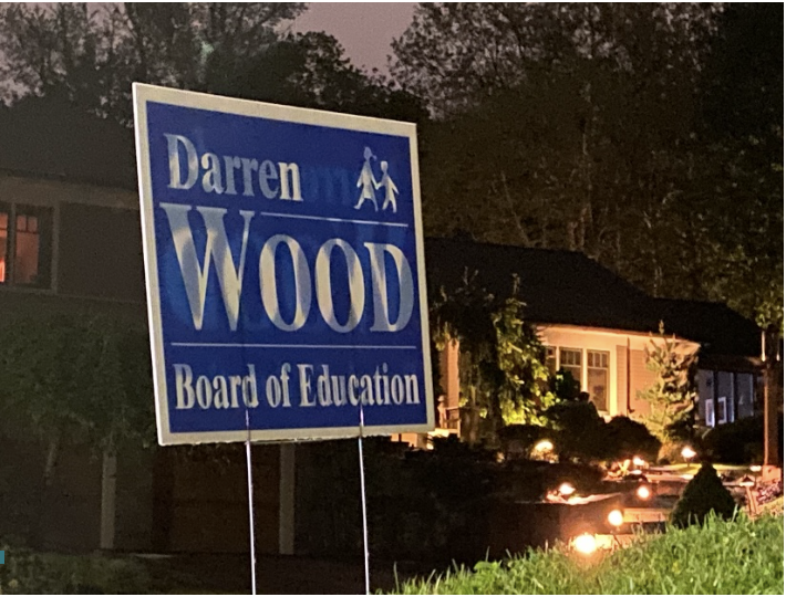 A campaign sign for Darren Wood can be seen on a lawn.