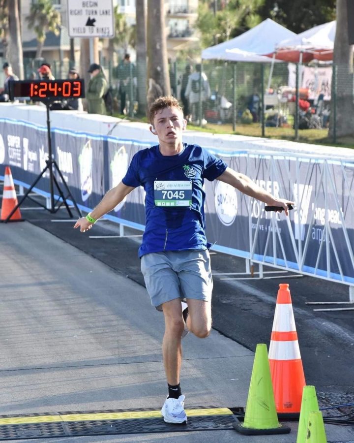 Junior Leo Schilling crosses the finish line in one of his several half marathons. Originally from the Cayman Islands, Schilling has brought his running talent to the cross country team this fall. 