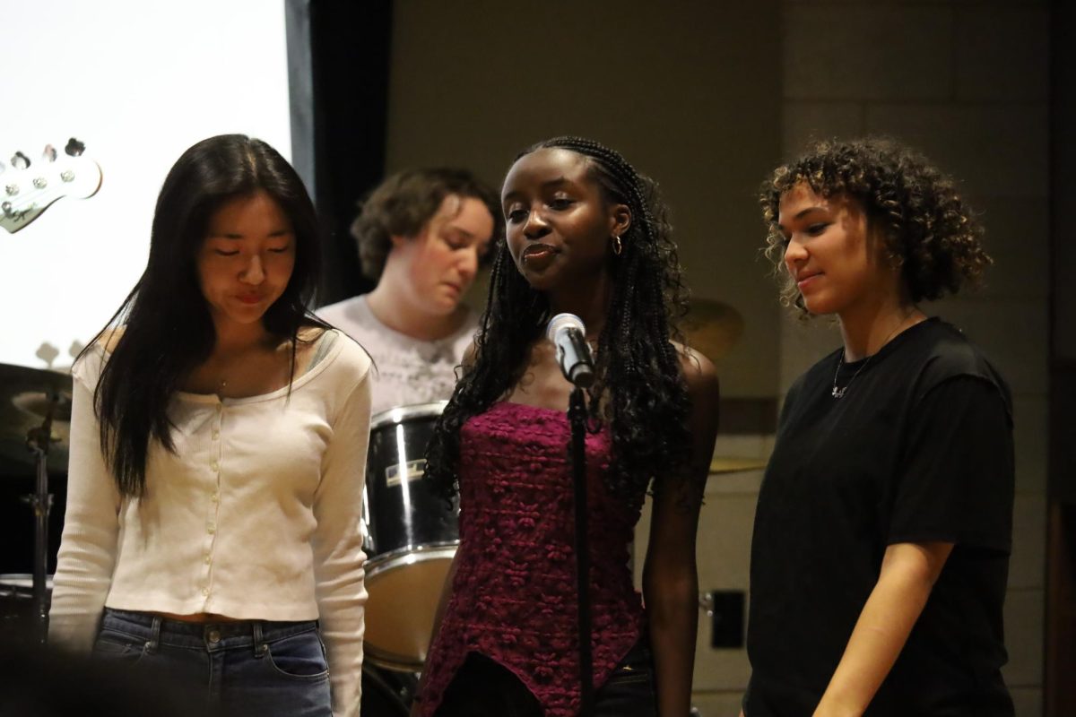 Murigande stands in the middle next to Eileen Kang to the left and Sienna Morin to the right. Together along with Positive Rhythm they performed You Know Im no good by Amy Winehouse at the fundraising concert to support their club leader, Murigande. 