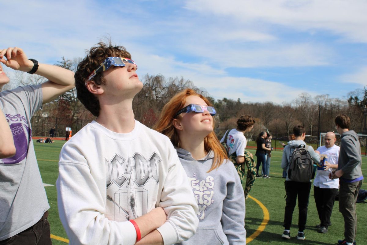 Students look at the crescent sun at 3:15 through eclipse glasses, which had been given out in advisory earlier that day. 