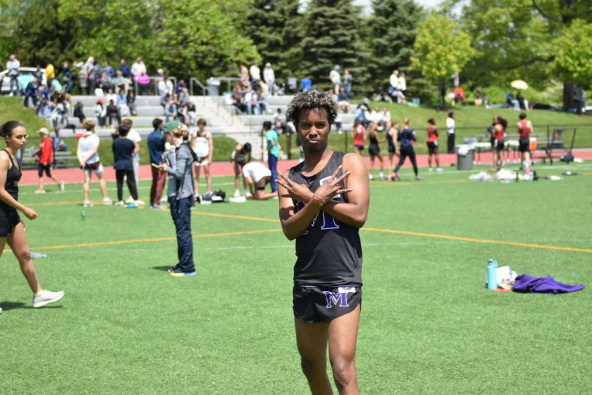 Warsameh Jama ‘25 posing in front of the busy FAA Brunswick meet. Jama ran the eight-hundred-meter race, finishing with a time of two minutes and six seconds. 
