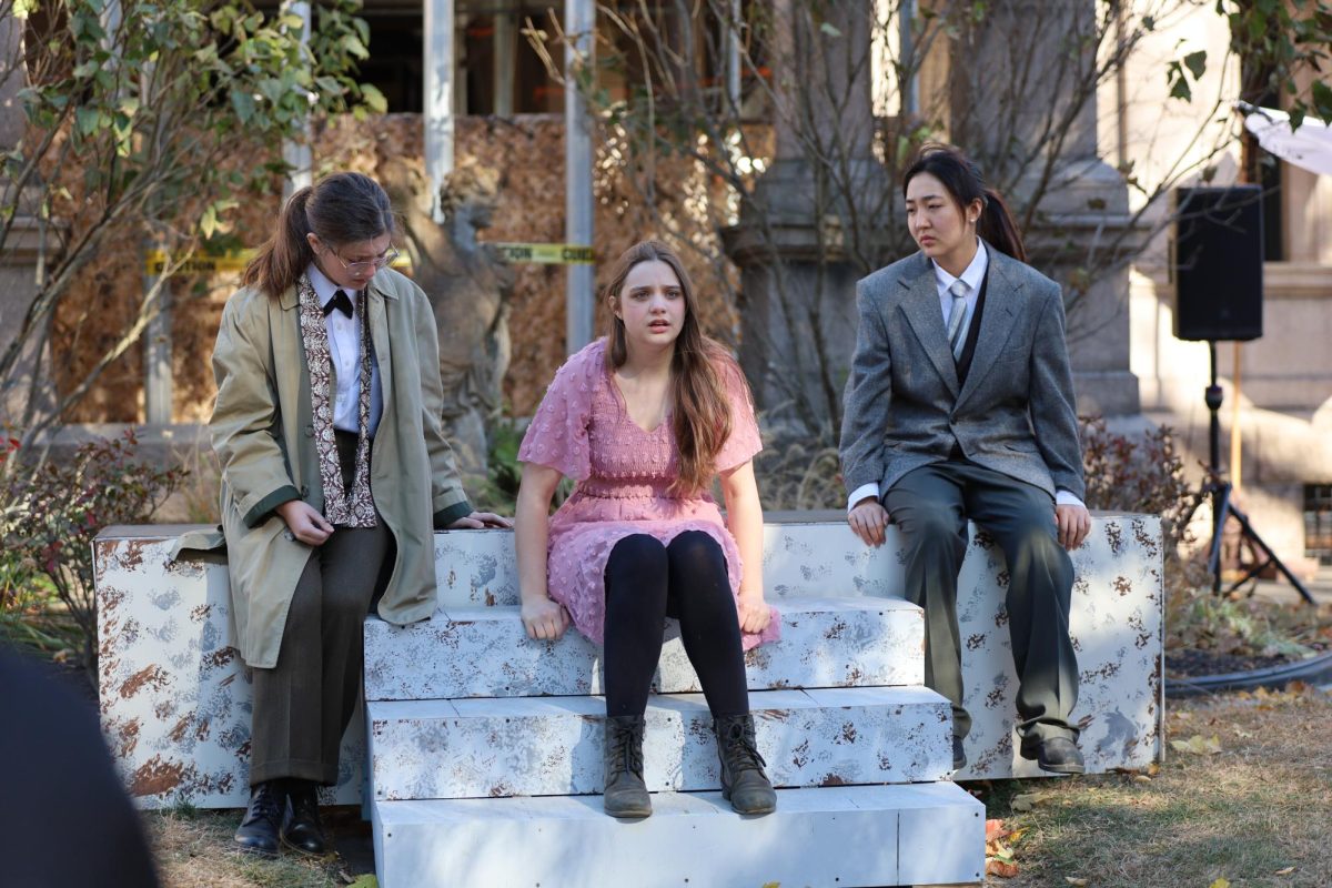 Josie Leff, '24, plays the lead role, Antigone, set in a World War II milieu, and is flanked by Eileen Kang and Ayalah Spratt, both '26, who play the king's aides in front of the historically landmarked Estherwood Mansion on campus. 