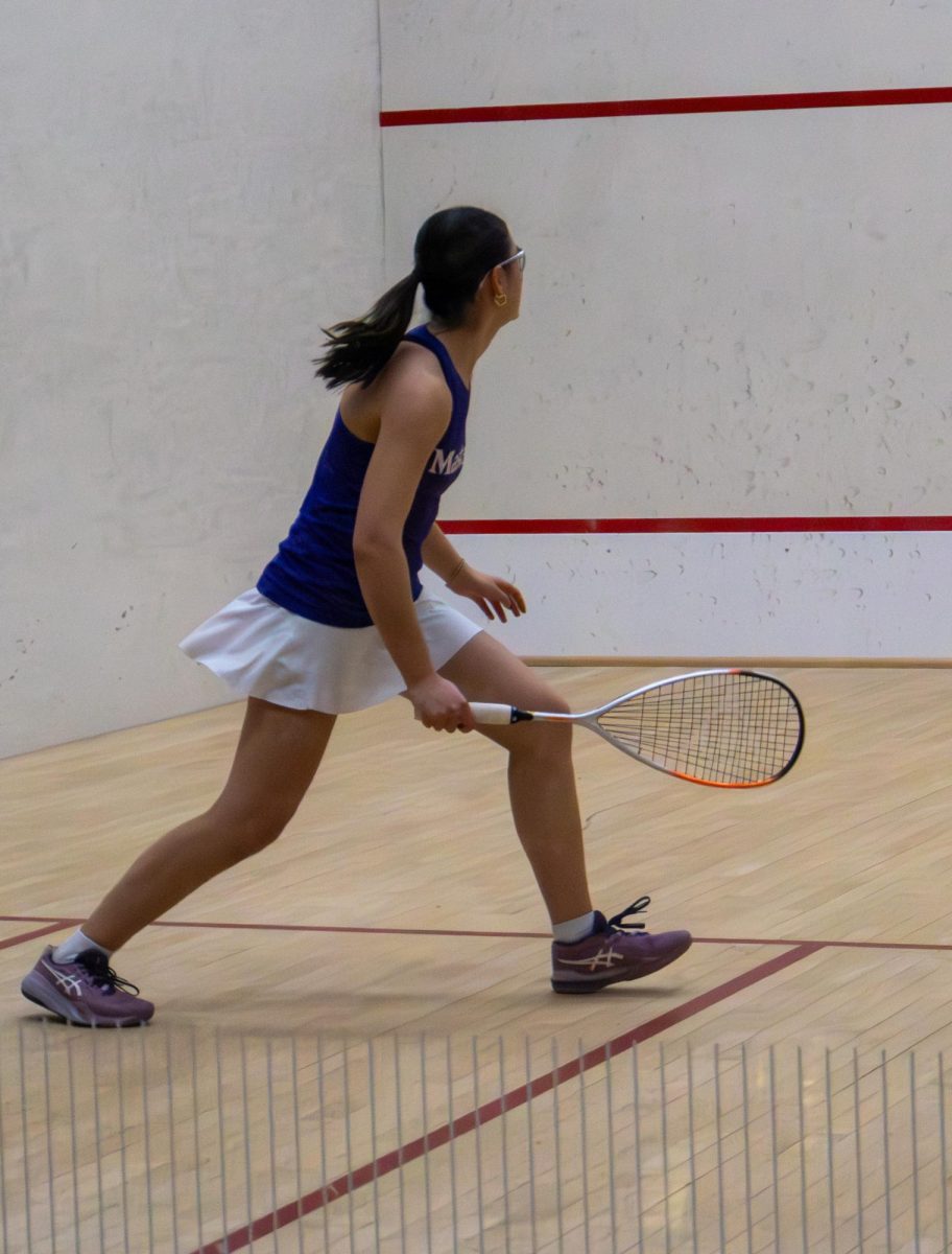 Clover Graves '27 hits a ball in a squash court.Graves began playing squash as a freshmen,when she joined the junior varsity team. This year, she returned to the sport as a varsity athlete.