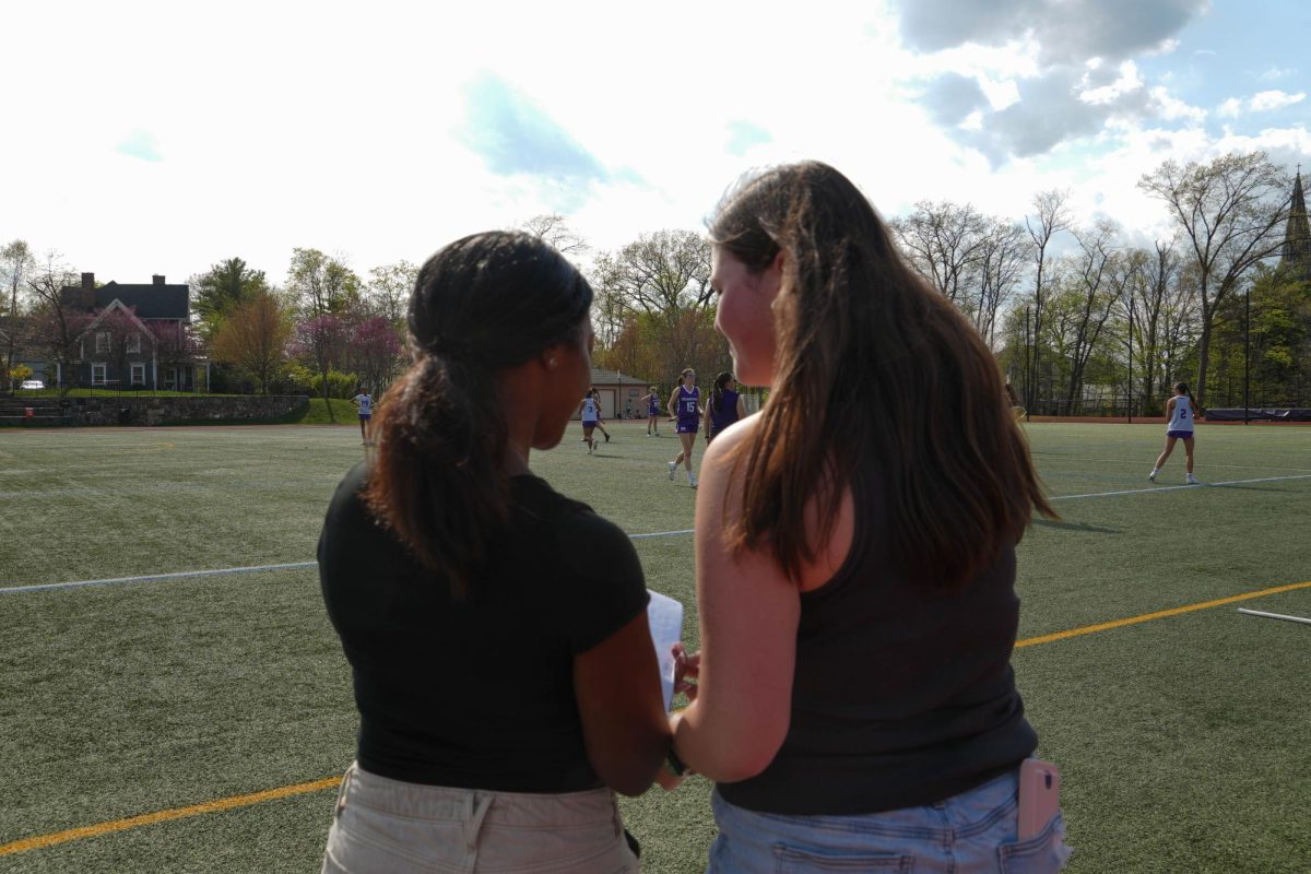 Team sport managers Willow Lovett and 	
Madelyn Lowe look over notes and discuss the game.  