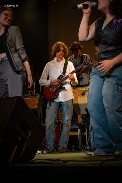 John Thorn 26’ plays the guitar among fellow students, this moment brought together through rehearsals and shared group dedication.