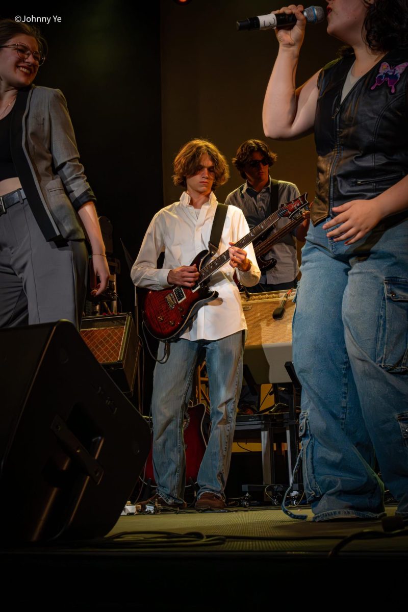 John Thorn 26’ plays the guitar among fellow students, this moment brought together through rehearsals and shared group dedication.