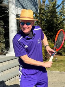 Tennis coach Warren Barest shows off one of his signature tracksuits on the tennis courts where he coaches. He played at Horace Greeley and Clark University before becoming a tennis professional. In his first year coaching at Masters, he has helped build a winning culture in the Masters varsity tennis team.