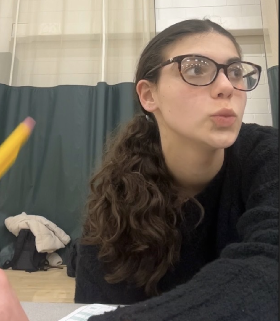 Sophie Ricks '27 carefully watches her team from the sidelines of practice. Ricks engages with the team by careful observation and detailed note-taking. 