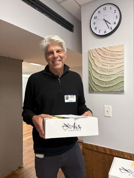 Jon Glaser, the founder of Aerin project, poses with a box of Aerin Project letters written by Masters middle school students. The letters contains words of support with the instruction of “Open when…” on the envelopes. The purpose of these letters is to make others and their emotions feel seen, even if it is anonymous.