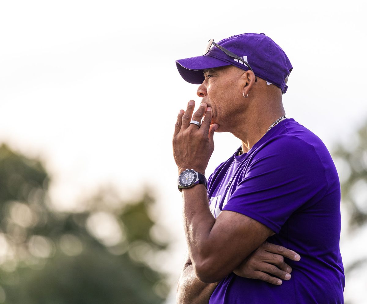 Coach PJ Johns stands deep in thought on the sideline. The field hockey team faces a total program transformation with five players completely new to the
sport. Coach PJ Johns’s positive mindset reflects a determination to teach his team resilience and accountability.